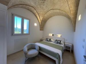 a bedroom with a bed with a chair and a window at Villa Chiara by salentoltremare in Corsano +39 photos