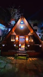 une maison avec des lumières à l'avant de celle-ci la nuit dans l'établissement Itzme Wings Resort, à Ooty