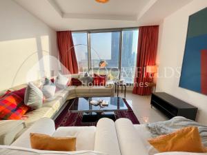 a living room with a couch and a table at Bloomfields Spacious 1br In Sun Tower in Mushayrib