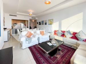 a living room with white couches and a table at Bloomfields Spacious 1br In Sun Tower in Mushayrib