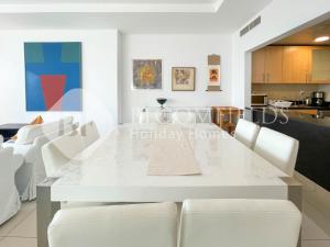 a white dining room with a white table and white chairs at Bloomfields Spacious 1br In Sun Tower in Mushayrib