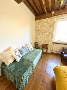 a bedroom with a bed and a couch in a room at Superbe maison en pierre in Sault-Brénaz