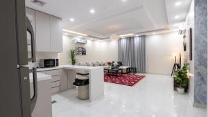 a kitchen and a living room with a couch at Cozy Escape in Dammam +34 photos