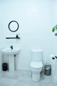 ein weißes Badezimmer mit Toilette und Waschbecken in der Unterkunft KB's Beach House in Langstrand + 30 Fotos