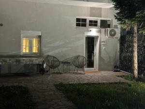 a patio with two chairs and a table in front of a house at Meteora Entry in Kalabaka