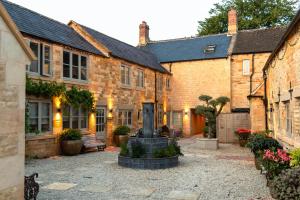 a courtyard with a fountain in front of some buildings at Luxury Cotswold Retreats in Moreton in Marsh