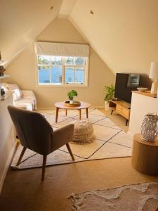 a living room with a chair and a television at Blue Pearl - Old Bar Holiday Rentals in Old Bar