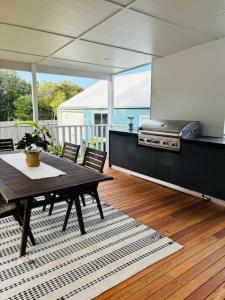 a kitchen with a table and chairs and a stove at Blue Pearl - Old Bar Holiday Rentals in Old Bar