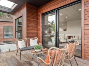 a patio with wicker chairs and a table at Refined Luxury – Modern 3-Bedroom House by Marina in Frankton Wharf