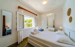 une chambre blanche avec une fenêtre et un lit avec des serviettes dans l'établissement Waterfront House Arnet by Villas Guide, à Potirna 23 autres photos