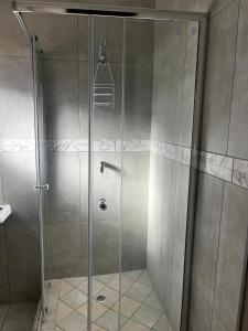 a shower with a glass door in a bathroom at Traquil Stays BnB in Klerksdorp