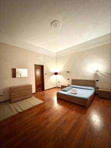 een slaapkamer met een bed en een houten vloer bij Milion's House Apartments in Salerno