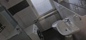 a bathroom with a sink and a toilet and a window at Monteurwohnung in Wissen