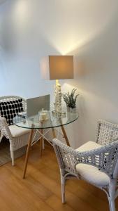 a glass table with a lamp and two chairs at Monte d'Alto in Santo Estêvão
