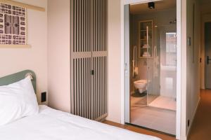 a bedroom with a bed and a bathroom with a toilet at Hotel Jansen Amsterdam Bajeskwartier in Amsterdam