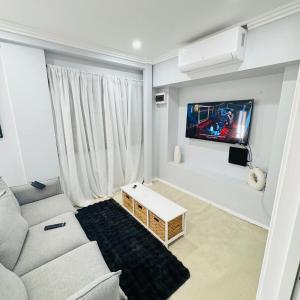 un soggiorno con un divano e una TV a parete di Charming Cozy Stay In Heart Of St Albans a St Albans