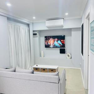 un soggiorno con un divano e una TV a parete di Charming Cozy Stay In Heart Of St Albans a St Albans