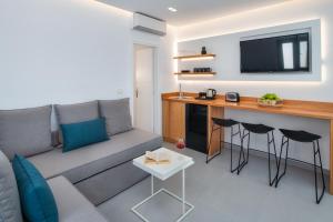 a living room with a couch and a table with stools at Harmony Suites in Fira