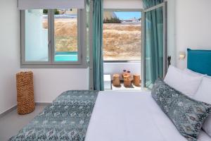 a bedroom with a bed and two windows at Harmony Suites in Fira +45 photos
