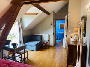 a living room with a blue couch and a table at Ferme de Montecouvez in Crèvecoeur-sur-lʼEscaut
