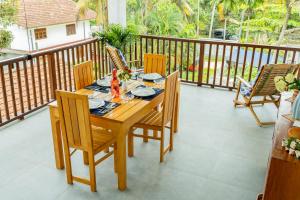 a wooden table and chairs on a balcony at Garden Villa Talalla in Talalla