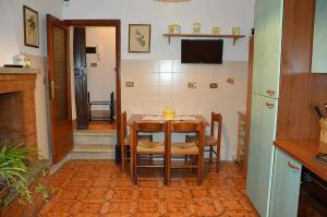 a kitchen with a table with chairs and a television at Le Scalette Casa Vacanze in Acquapendente +3 photos