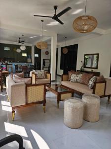 a living room with couches and a table and chairs at Jungle Soul in Mirissa