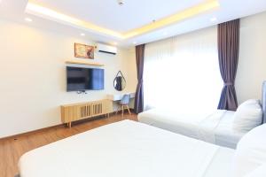a hotel room with two beds and a flat screen tv at FLC SEA TOWER YẾN MINH Apartment in Quy Nhon