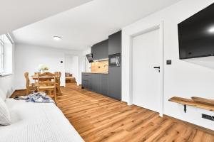 a room with a bed and a kitchen with a table at Residence Koubek - stylové apartmány s parkováním in Boží Dar