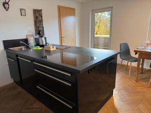 a kitchen with a black island with a sink at Am Stadtpark in Reutte