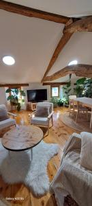 a living room with a table and couches at Le Grenier des Moineaux Chezchristineetfabrice in Odeillo-Via