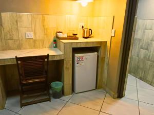 a kitchen with a counter and a small refrigerator at The Wilds Guest House in Hluhluwe +29 photos