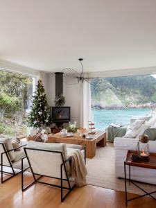 a living room with a christmas tree in the window at Wishome- Villa sobre el mar, piscina climatizada in Pechón