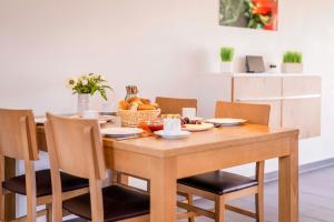 a dining room table with chairs and a bowl of fruit at Ferienhauspark Asgard in Damp in Damp +36 photos