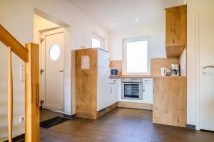 a kitchen with a white refrigerator and a window at Ferienhauspark Asgard in Damp in Damp