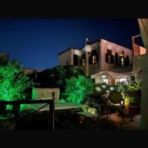 - une vue nocturne sur un bâtiment avec des lumières vertes dans l'établissement boutique hotel, à Mesochórion