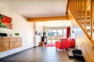 a living room with a red chair and a staircase at Ferienhauspark Asgard in Damp in Damp