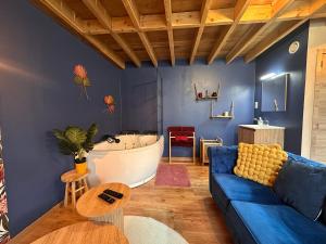 乌伊埃La Hour House - Esc'Appart的客厅配有蓝色的沙发和浴缸