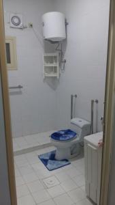 a bathroom with a toilet with a blue seat at شركة العييري للشقق المخدومة - إقتصادي Al-Eairy Serviced Apartments Company in Al Hofuf
