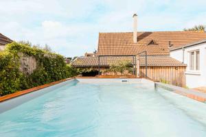 a swimming pool in the backyard of a house at CHEZDAMDAM - la Villa du Thar - plage 300m piscine babyfoot arcade pingpong pétanque in Saint-Pair-sur-Mer