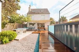 a backyard with a pool and a house at CHEZDAMDAM - la Villa du Thar - plage 300m piscine babyfoot arcade pingpong pétanque in Saint-Pair-sur-Mer