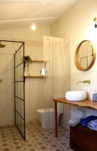 a bathroom with a sink and a toilet and a mirror at Casa de la Senda in Candeleda
