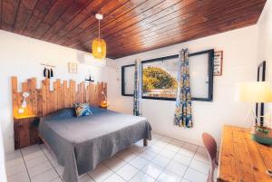 a bedroom with a bed and a window at Kaz Nomia - à 50m de la plage Roches Noires in Saint-Gilles les Bains