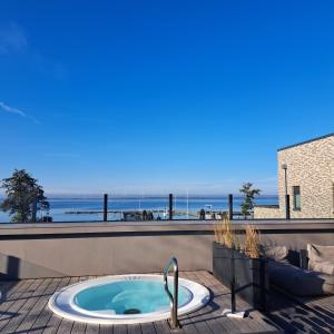 a hot tub on a patio with a view of the ocean at SeeZeit, Ferienhaus bis zu 6 Personen, 500 Meter zum Wasser, mit Garten in Hüde
