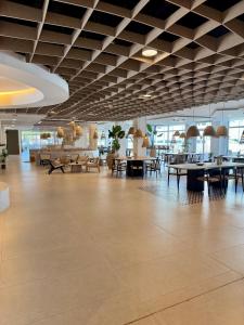 a large lobby with tables and chairs in a building at Canvas Sevilla Lago in Seville