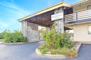 a building with a sign for a parking lot at Brookville Inn By OYO Near Dayton International Airport in Brookville