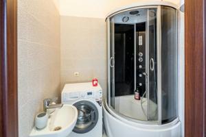 a small bathroom with a washing machine and a sink at Studio on Kopernyka street in Lviv