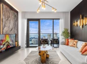 a living room with a couch and a tv at Novity Luxury Vida Marina 2BR Sea View 40th Floor in Dubai