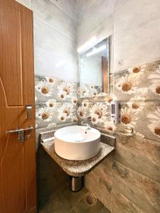 a bathroom with a sink and a flower patterned wall at Zuna Stayz Tapovan Rishikesh in Rishīkesh