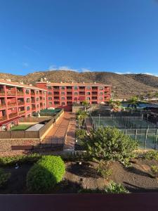 a building with a tennis court in front of it at El Mocan Apartment Palm Mar in Palm-mar